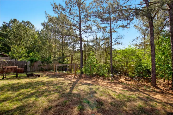 This spacious yard offers a serene retreat with mature trees and ample outdoor space.