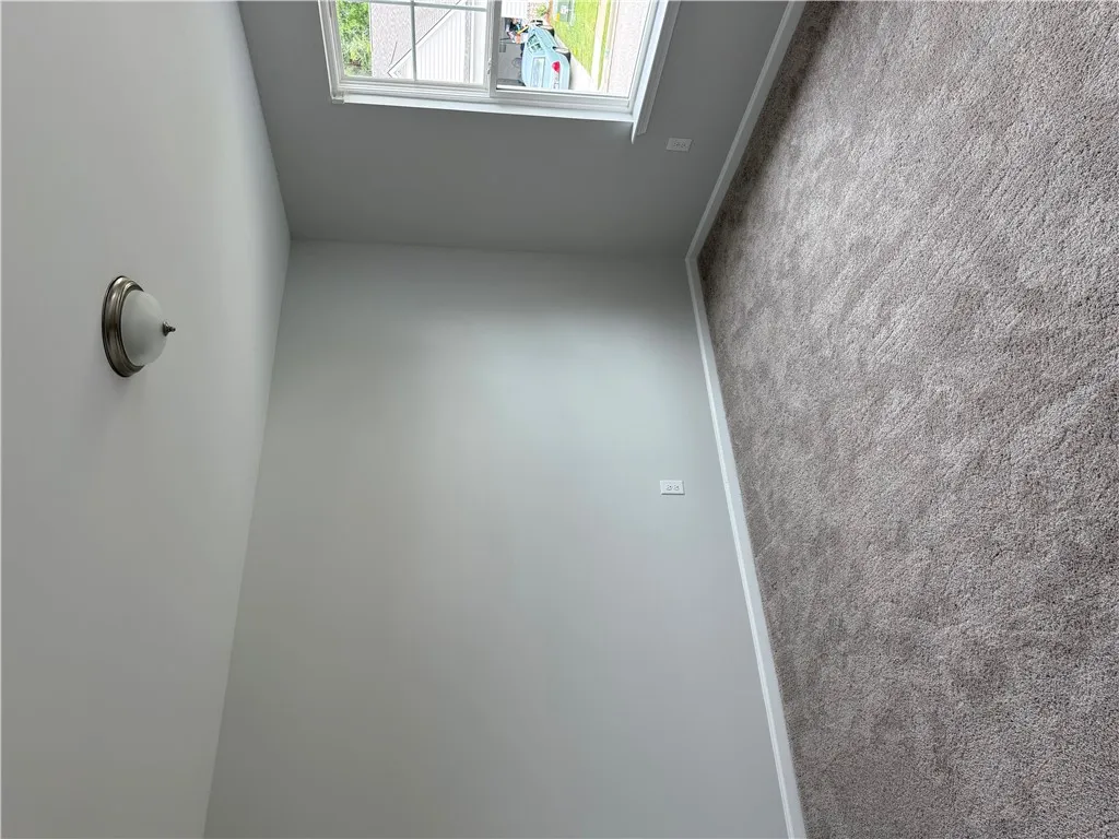 A window bathes this carpeted interior space in natural light, ready for your personal touch.