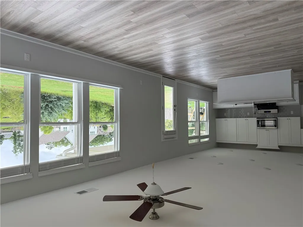 An open concept living area boasts a modern kitchen with ample cabinetry and sun-filled windows.