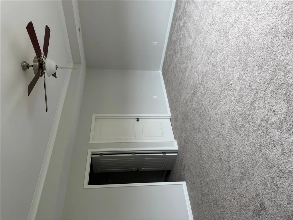 Plush carpeting and a ceiling fan create a comfortable atmosphere for relaxation.