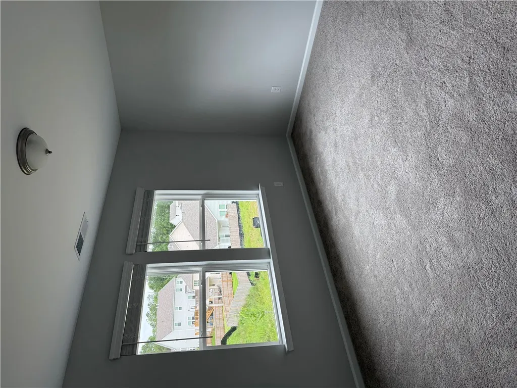 Plush carpet and bright windows define this inviting, comfortable bedroom space.