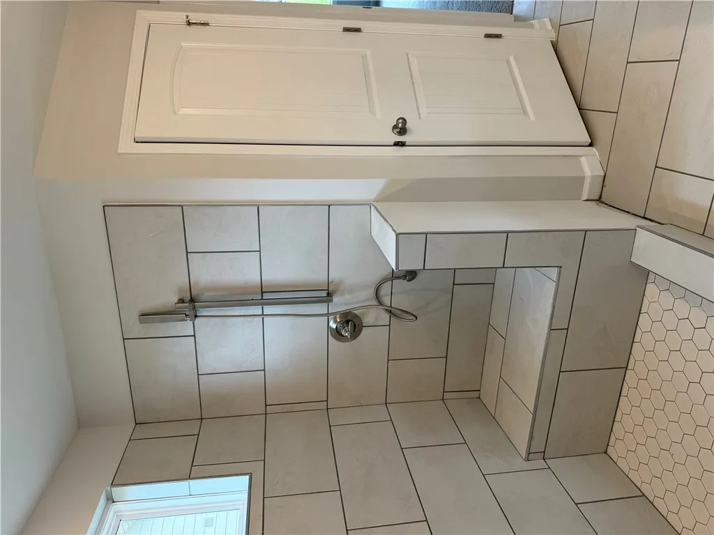 A spacious, tiled shower features a built-in bench and a window for natural light.