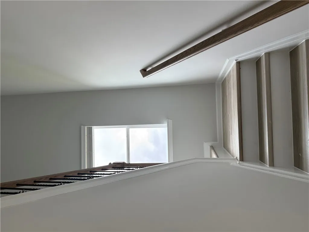 Artfully crafted wood and iron railings define a striking ascent towards an naturally illuminated upper landing.