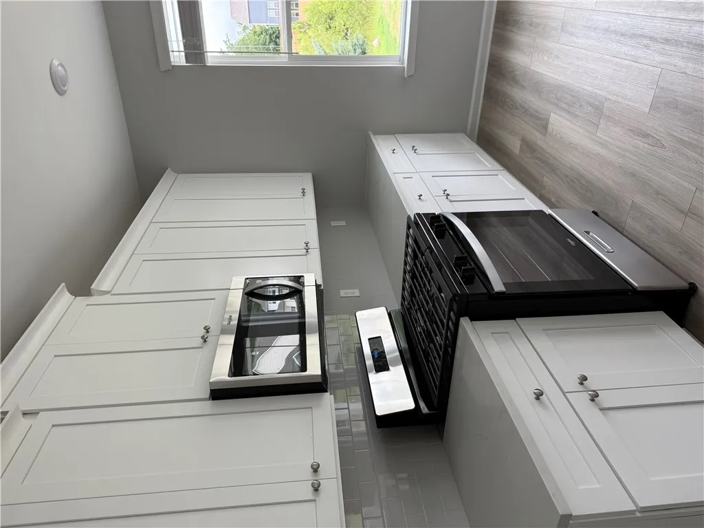 A well-equipped kitchen features pristine white cabinetry and contemporary appliances, perfect for culinary adventures.