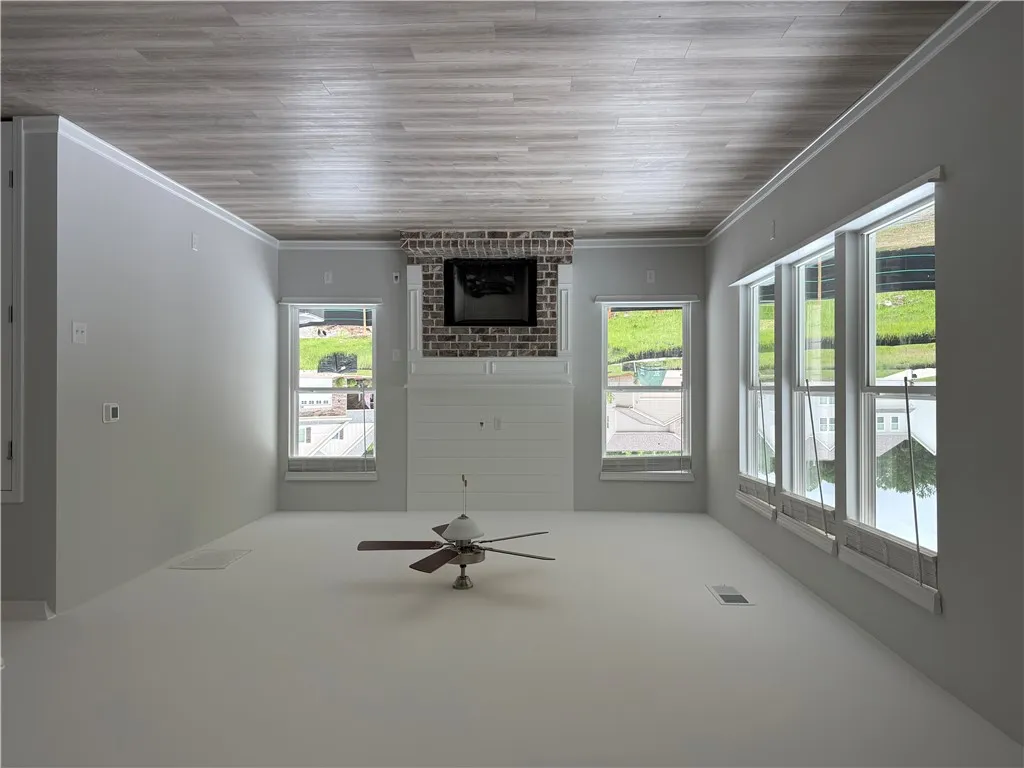 A welcoming great room, featuring a cozy fireplace and abundant natural light from numerous windows.