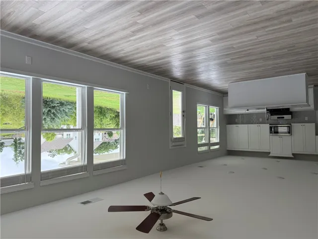 An open concept living area boasts a modern kitchen with ample cabinetry and sun-filled windows.