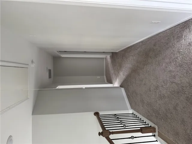 A well-maintained hallway with plush carpet and elegant stair railing awaits.