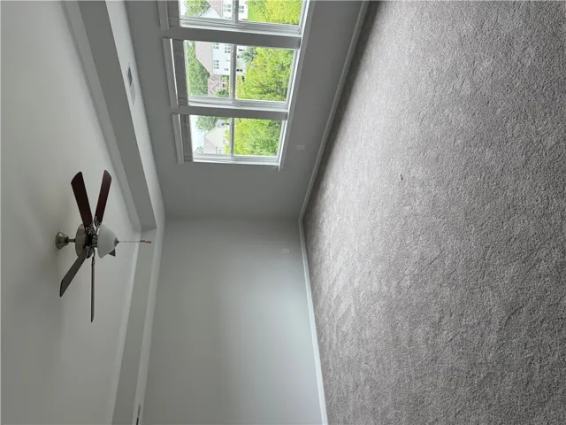 A generous room featuring ample natural light and plush carpeting.
