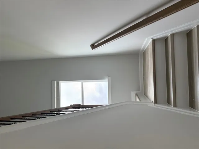 Artfully crafted wood and iron railings define a striking ascent towards an naturally illuminated upper landing.