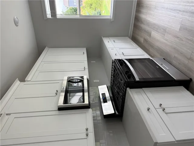 A well-equipped kitchen features pristine white cabinetry and contemporary appliances, perfect for culinary adventures.