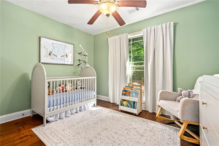 This cozy bedroom features hardwood floors and a bright window.
