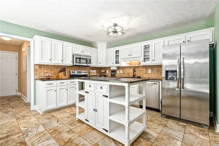 This spacious kitchen offers ample storage and a central island, perfect for culinary endeavors.