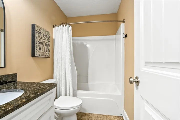 This bathroom features a contemporary vanity and a practical shower-tub combination, providing essential comfort.