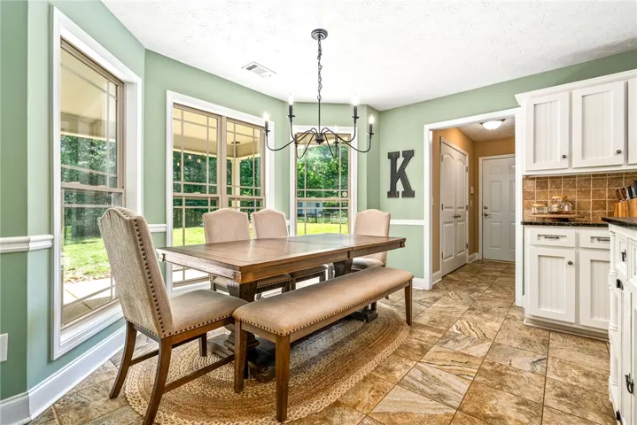 This bright dining area features ample natural light and a tiled floor, perfect for gatherings.