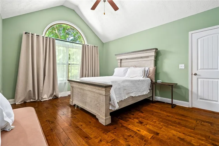 This spacious bedroom offers abundant natural light and elegant hardwood flooring.