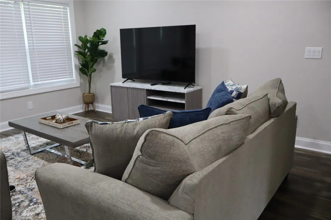 This living area boasts rich wood flooring, crisp white trim, and abundant natural light.