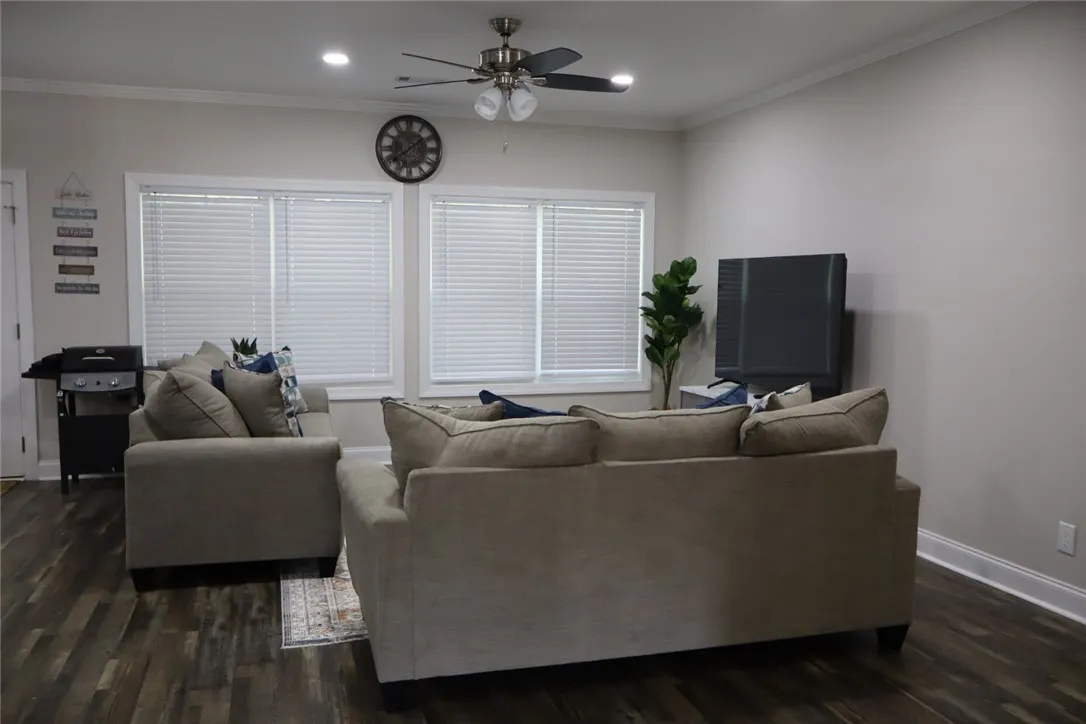 This inviting living room boasts ample natural light and rich wood flooring.