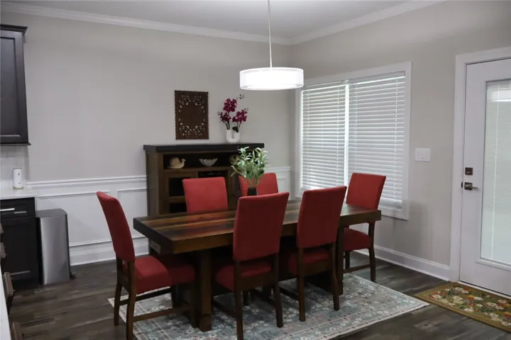 This inviting dining area features elegant crown molding and rich hardwood flooring, perfect for gatherings.