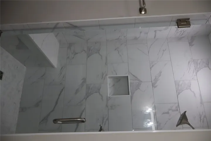 This sleek shower features a spacious built-in bench and elegant tiled walls for a refreshing experience.