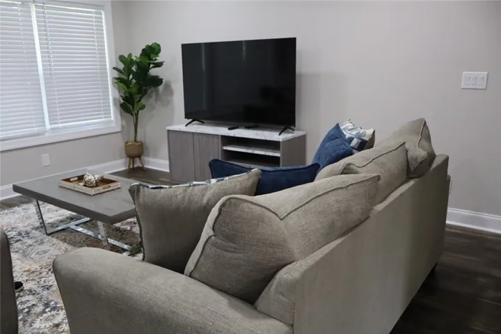 This living area boasts rich wood flooring, crisp white trim, and abundant natural light.