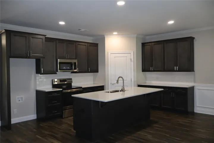 This modern kitchen features a spacious island and sleek cabinetry, perfect for entertaining and daily living.