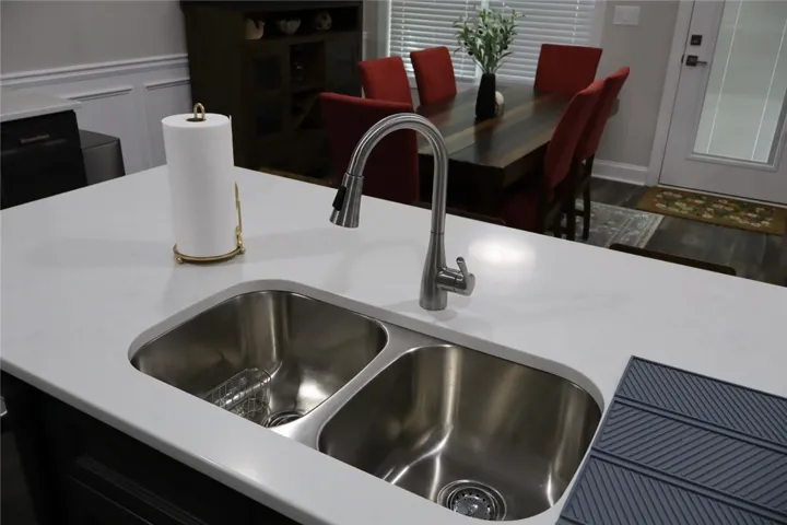 This kitchen boasts a double basin sink and a modern pull-down faucet, ideal for everyday living.