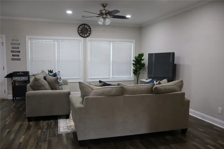 This inviting living room boasts ample natural light and rich wood flooring.