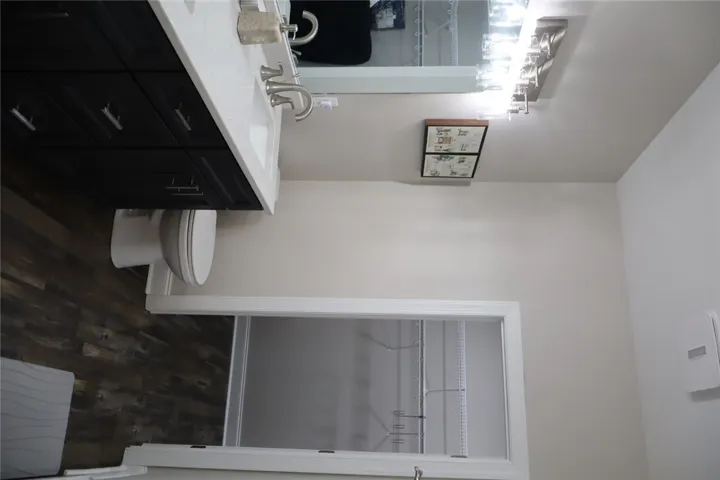 This bright bathroom features a spacious vanity and convenient closet access.