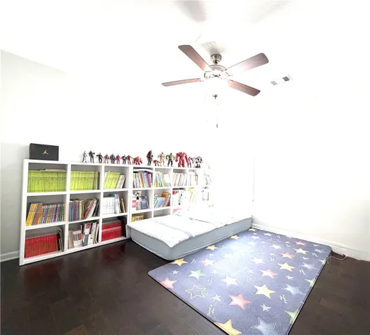 This spacious bedroom features warm hardwood floors and abundant natural light.