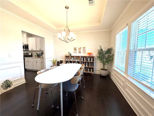 This elegant dining space features rich dark flooring and abundant natural light.