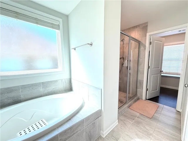 Relax and refresh in this tranquil bathroom, featuring a soaking tub and spacious shower.