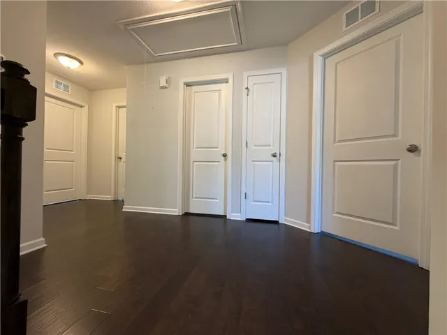 This spacious hallway features rich hardwood flooring, creating a seamless flow throughout the home.