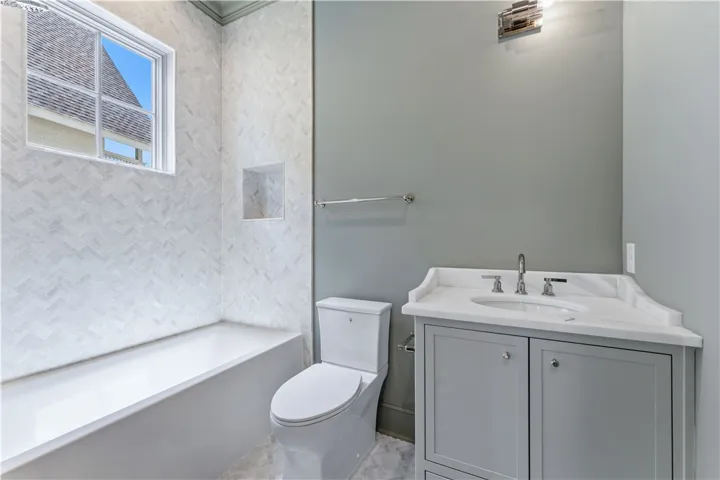 This bathroom features a sleek vanity, modern fixtures, and elegant tile work.