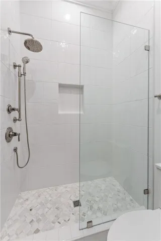 This modern shower enclosure features clean lines and a tiled floor, creating a bright and inviting space.