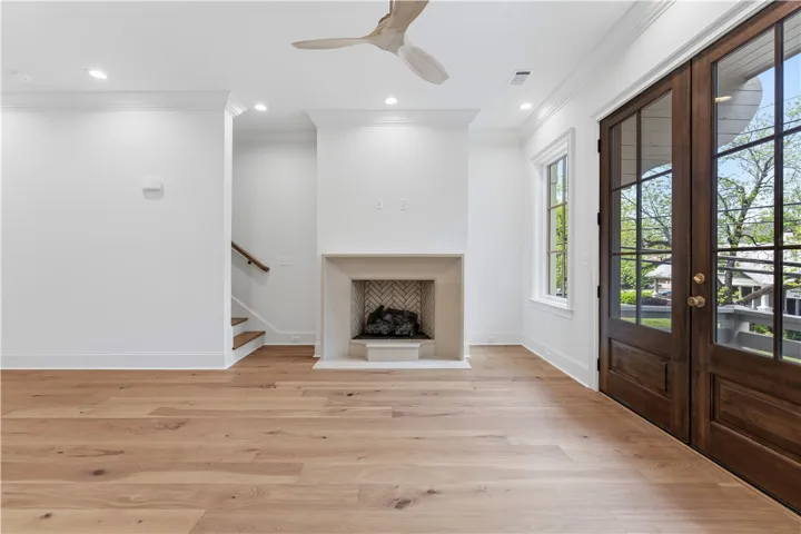 This bright living area features a fireplace and elegant hardwood flooring, perfect for comfortable living.