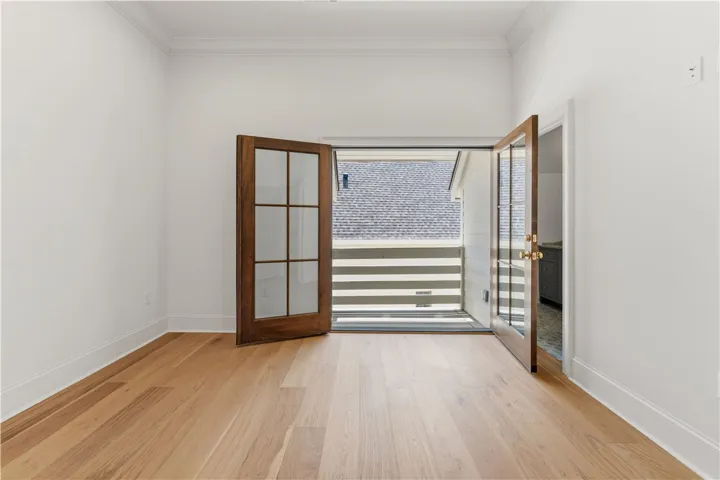 This bright space features elegant hardwood flooring and direct access to an outdoor balcony.