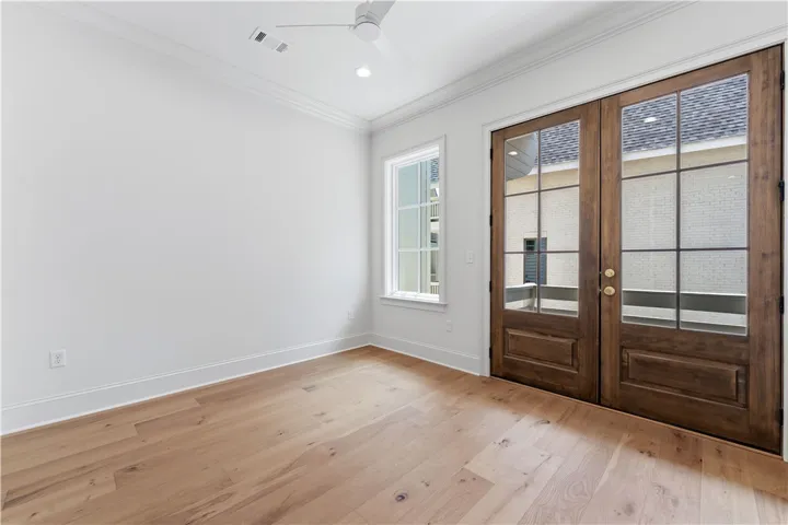 This bright space features gleaming hardwood floors and elegant French doors, creating an inviting atmosphere.