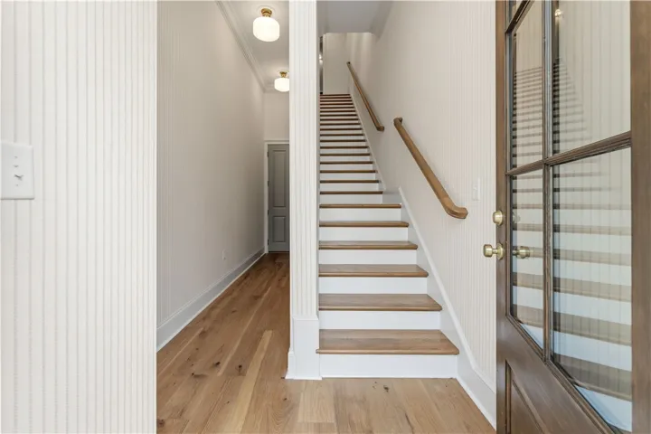 This inviting entryway features wood flooring and a staircase leading to the upper level.