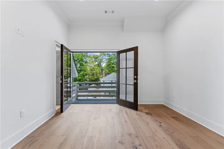 This bright space features French doors opening onto a private balcony.