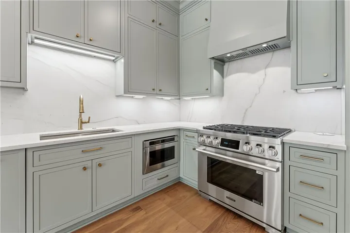 This modern kitchen features light-toned cabinetry, gleaming countertops, and premium stainless steel appliances.