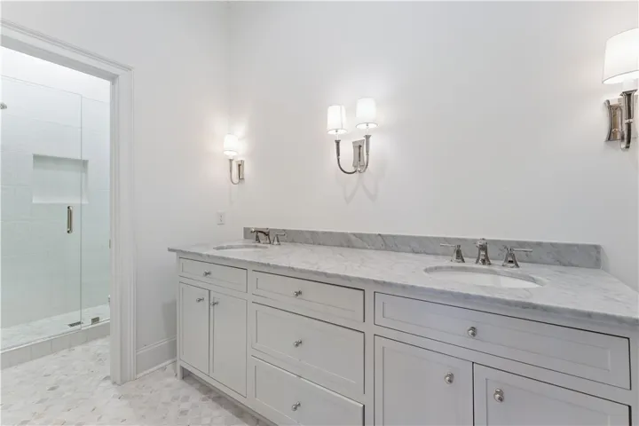 This serene bathroom offers a spacious double vanity with ample counter space and a refreshing walk-in shower.