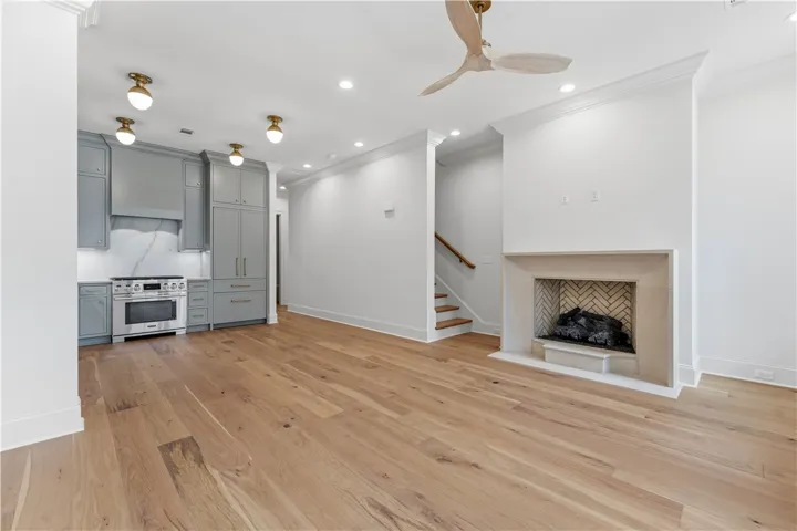 This inviting space features an open layout with a kitchen, a fireplace, and hardwood flooring.