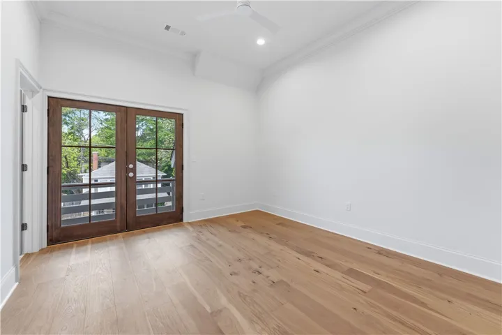 This spacious room features rich hardwood flooring and French doors leading to a private balcony.
