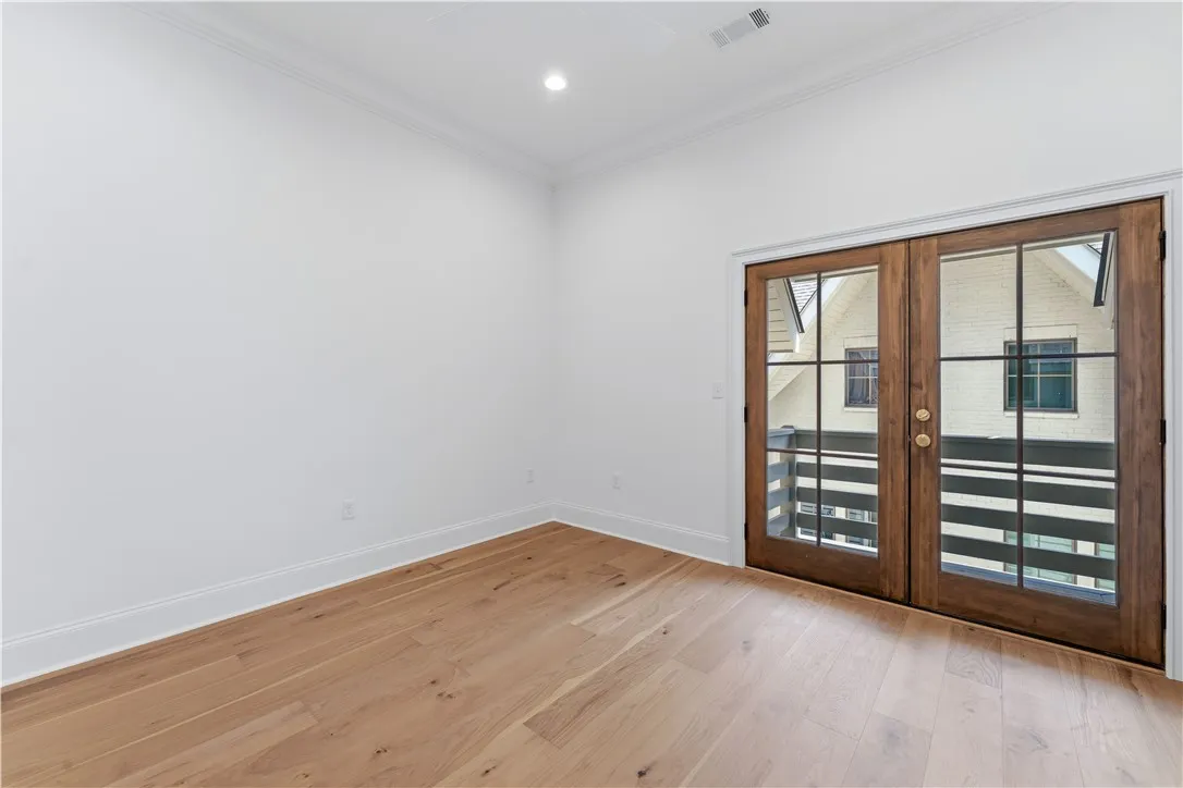 This bright space offers rich hardwood flooring and french doors that open to a balcony.