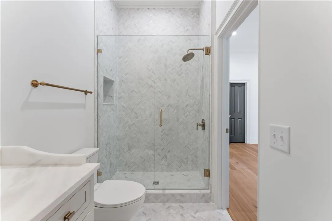 This bathroom features a contemporary shower with herringbone tile and sleek fixtures.