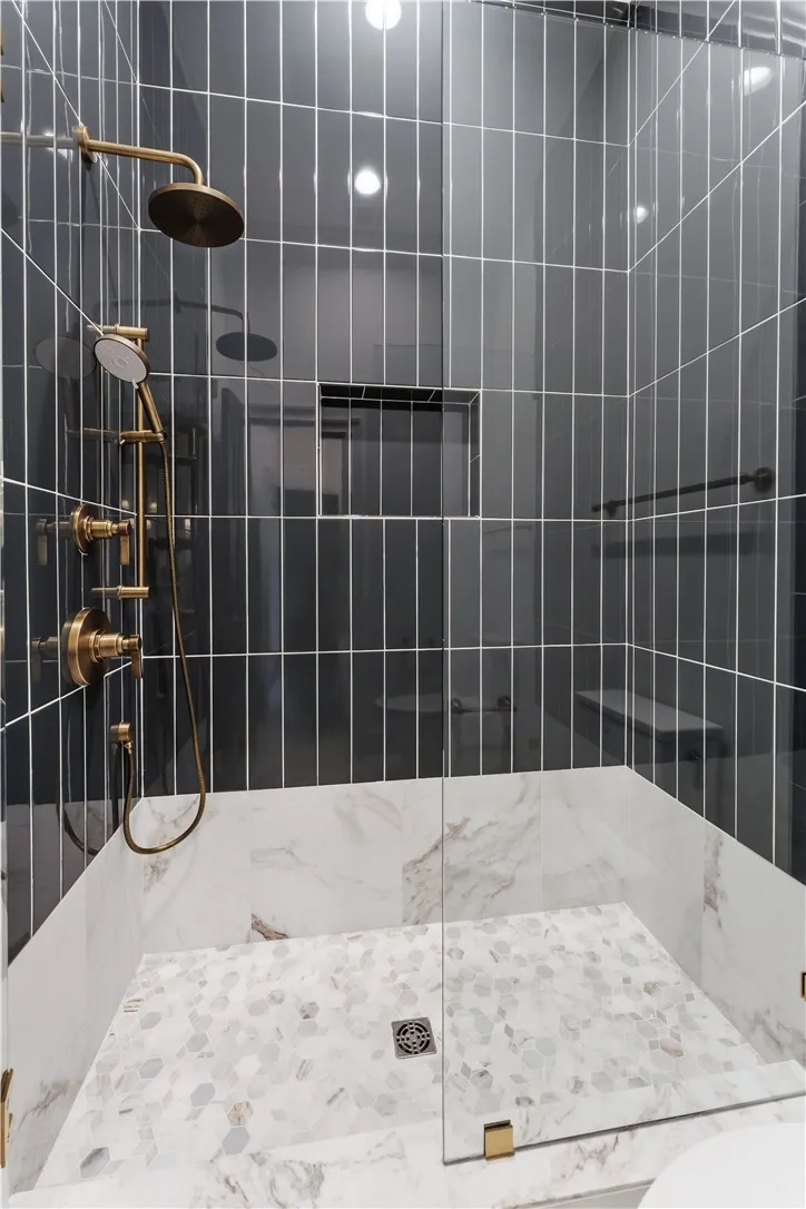 This sleek shower features modern fixtures and exquisite tiling.