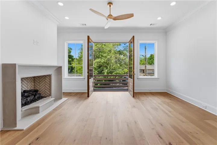 This airy room features a fireplace and a balcony, perfect for relaxation or entertaining.