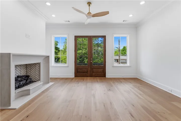 This bright living space features elegant French doors and a cozy fireplace, perfect for relaxation.