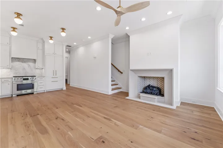 This bright, open-concept living space boasts sleek hardwood floors and a modern fireplace, perfect for gatherings.