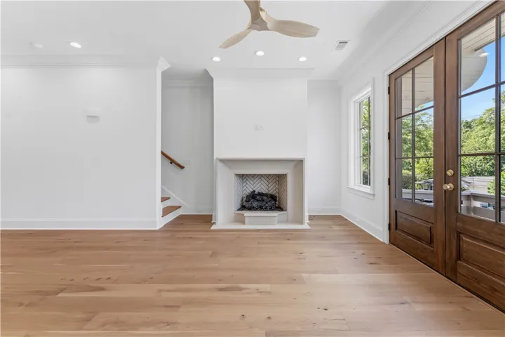 This bright living space features hardwood floors and a cozy fireplace, perfect for gatherings.